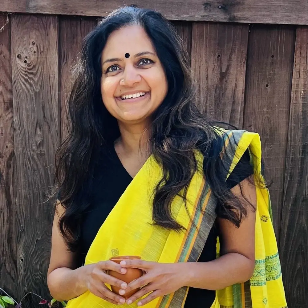 Anjali Rao smiling while holding a cup of tea