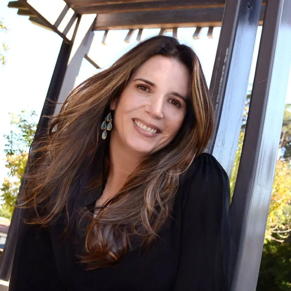 Elizabeth Little smiling under a pergola outdoors