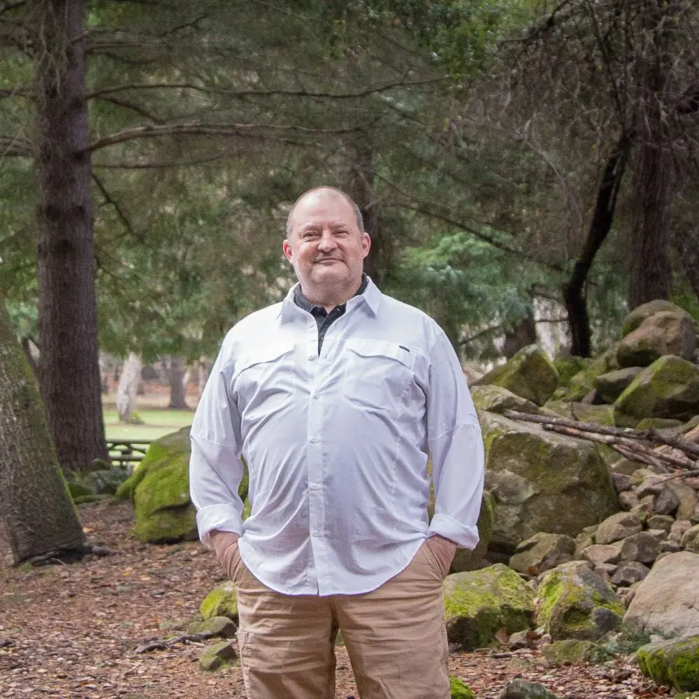 Jim Patton standing in a forest.