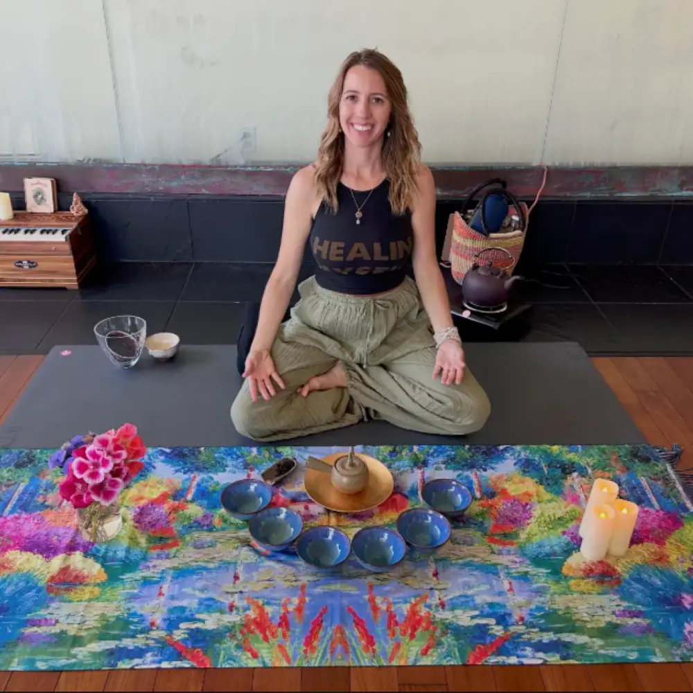 Katie Davidson seated in a yoga studio next to a tea display