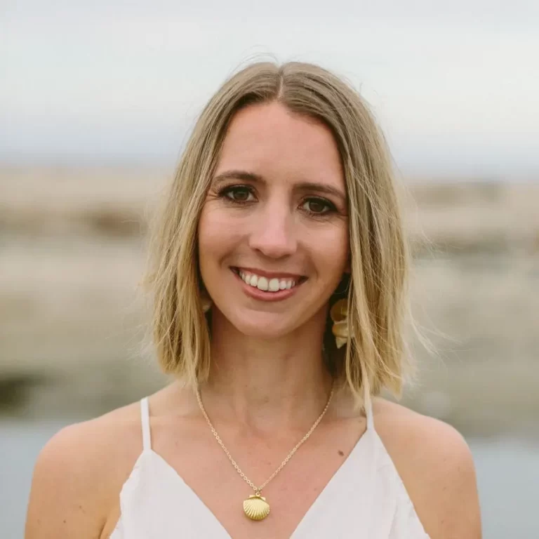 A headshot of Katie Davidson smiling on the beach.