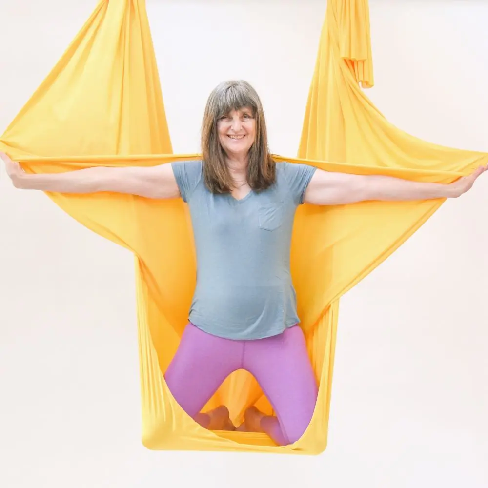 Sarah Khayat in an aerial sling, smiling.