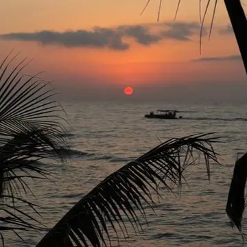 An ocean view of the sun setting in Roatan