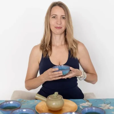 Katie seated in front of a tea set