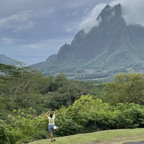 Sandhya in tree pose facing a mountain