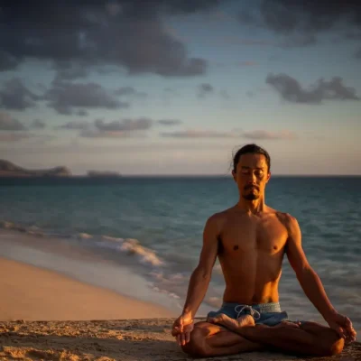 Atsuro Chiba meditating in lotus pose on a beach
