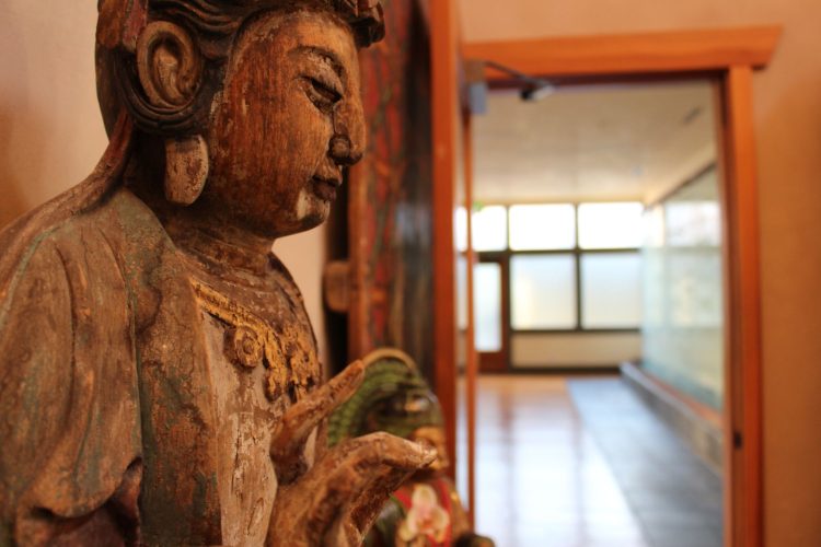 Buddha statue profile in front of a yoga room