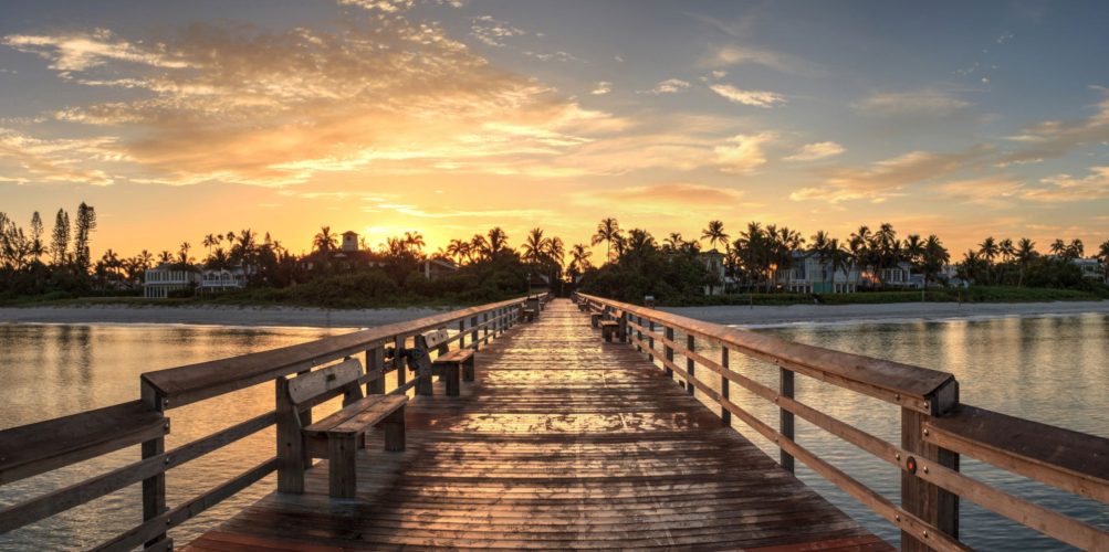 Early sunrise over the Naples Pier on the Gulf Coast of Naples, Florida in summer.