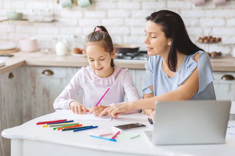 Private tutoring. Little girl having lessons with tutor at home, copy space