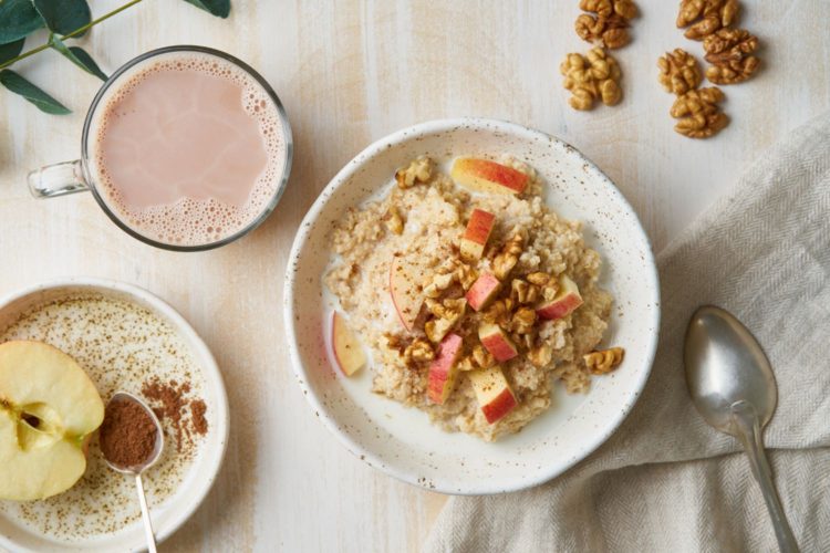 Oatmeal with apple, nuts, honey and cup of chocolate on white wooden light background. Top view. Healthy diet breakfast (Oatmeal with apple, nuts, honey and cup of chocolate on white wooden light background. Top view. Healthy diet breakfast, ASCII, 12