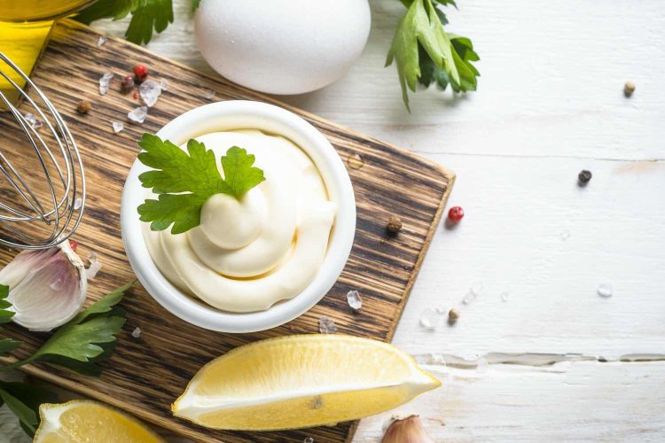 Mayonnaise sauce and ingredients on white stone table. Top view with copy space.