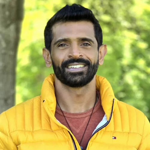 picture of yoga teacher prashant shetter in bright yellow jacket