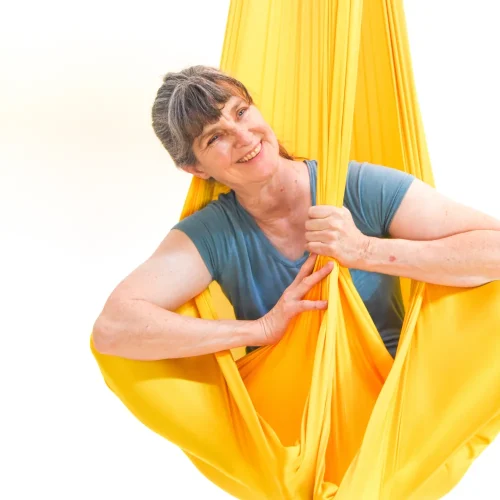 sarah in a yellow aerial hammock smiling