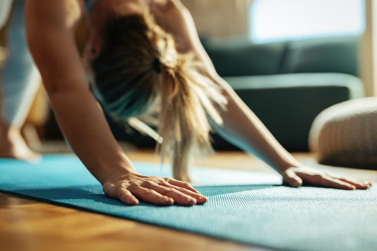Close-up of athletic woman doing Yoga stretching exercises at home