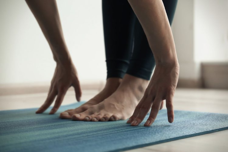 Young woman practicing yoga indoors, closeup