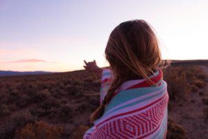 woman wrapped in blanket in nature